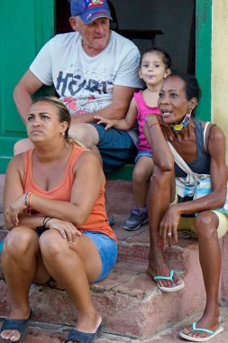 Trinidad, Küba, Mayıs 2022: Yerli halk evlerinin önünde oturuyor