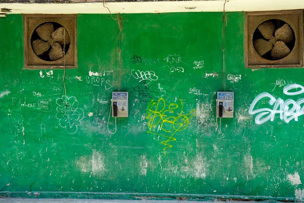 Havana, Küba, Mayıs 2022: Çürük hayranlar ve ankesörlü telefonlar greel duvarda