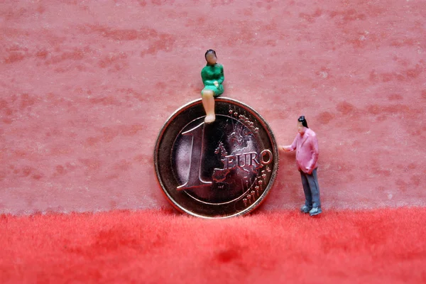 Woman sitting on euro coins — Stock Photo, Image