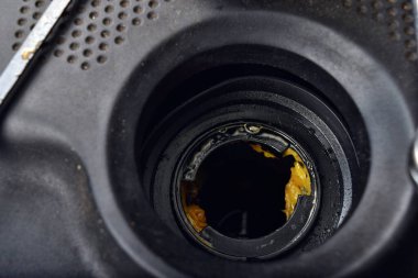Yağ kapağının altındaki kalın, yağlı sarı motor yağı şişmiş bir contanın belirtisi ve belirtisidir. Bir araba bozuldu.