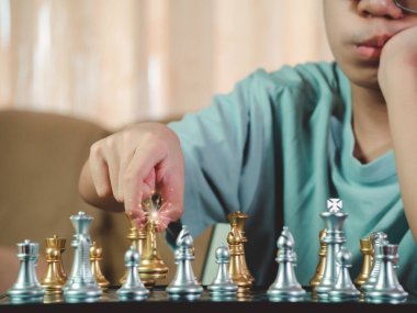 Satranç hamlesi, strateji geliştiren, akıllı konsantrasyon ve satranç oynarken düşünen çocuk için masa oyunu oynayan konsantre olmuş ciddi bir çocuk. Öğrenme, taktik ve analiz kavramı. 