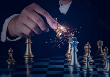 El işadamı, satranç tahtasında satranç tahtasında satranç oynamak için gümüş şövalyeyi ateşle dövüştürüyor. Yönetim veya liderlik stratejisi ve takım çalışması kavramı.