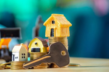 Ev veya ev modeli üzerinde yakın sikke yığını ile ev anahtarı. Kavramı kredi için mülkiyet merdiven, finans, mortgage, gayrimenkul yatırım, vergiler ve bonus.
