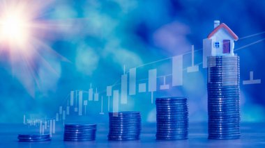 Sikkeler, gelecek için para biriktirmek amacıyla tahta bir masaya 4 sıra altın ve beyaz bir kumbara yığar. Kredi, emlak merdiveni, mali, gayrimenkul yatırımı, vergiler ve ikramiye kavramı.