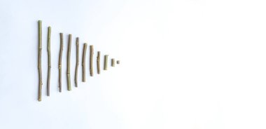 Üçgen şeklindeki kuru çubukların basit bir bileşimi, beyaz arkaplandaki oklar. Metin için boşluk. Kartpostal, işaretçi, pankart