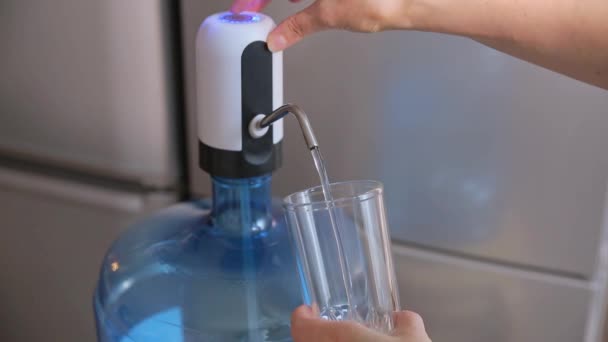 Czystą wodę pitną wlewa się do szklanki za pomocą pompy. — Wideo stockowe
