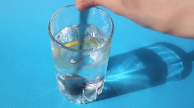 Temiz içme suyuna bir dilim limon eklenir ve kaşıkla karıştırılır..