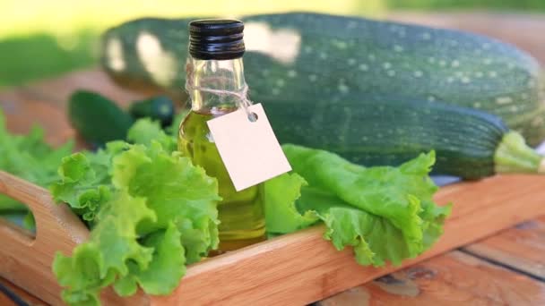 Plantaardige olie in een kleine glazen fles met een kartonnen etiket — Stockvideo