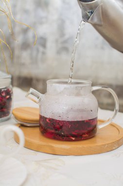 Ahşap tezgahta kırmızı meyve çaydanlığı..