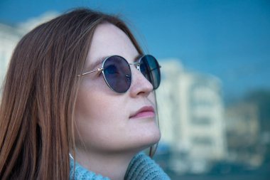 Çilli, uzun saçlı ve gözlüklü güzel bir kadın. Yüzünü kapat.