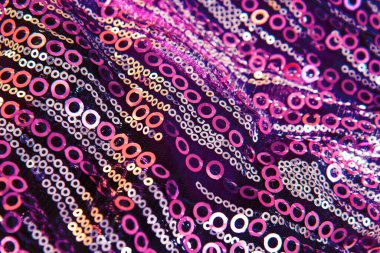 Pembe parlak kumaş, pullar ve parlak boncuklar. Pembe kumaş dokusunun örtülü arka planı. Uzayı kopyala Kapat.