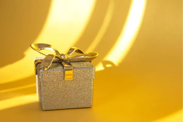 Glänzende Silberne Geschenkschachtel Mit Goldener Schleife Auf Hellem Goldgrund Urlaubskonzept — Stockfoto