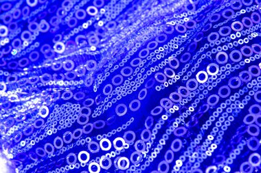 Güzel mavi parlak kumaş, pullar ve parlak boncuklar. Mavi kumaş dokusunun örtülü arka planı. Uzayı kopyala Kapat.