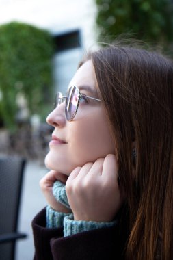 Koyu renk ceketli, çilli ve gözlüklü güzel bir kadın yüzü. Yaşam biçimi