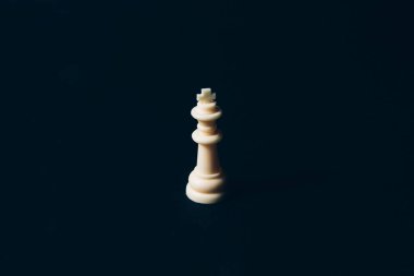 White chess queen on a black background. Abstract background