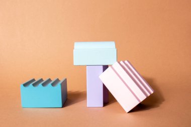 Geometrik şekiller ürün gösterimi için podyum oluşturur. Pastel arka planda parlak soyut şekillerin çok renkli mimarisi. Sunum için arka plan. Minimalizm tarzı.