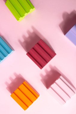 Ürün sergisi için parlak, renkli geometrik şekiller podyumu. Pastel arka planda parlak soyut şekillerin çok renkli mimarisi. Sunum için arka plan. Düz yatıyordu