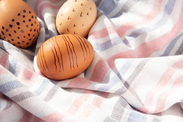 Tekstil arka planında renkli el yapımı Paskalya yumurtaları. Minimum konsept. Kopyalama alanı olan yan görünüm