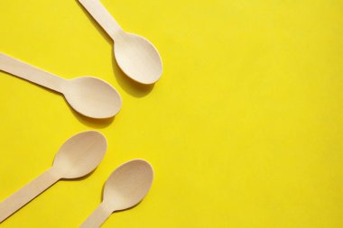 Parlak sarı arka planda ahşap bambu çatal bıçak takımı