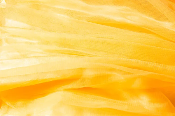 Bellissimo tulle giallo nudo con sfondo perline lucide. Sfondo drappeggiato di tessuto in polvere rosa, texture — Foto Stock