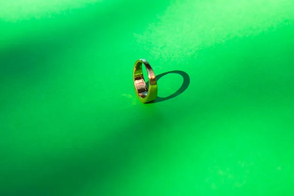 コントラストの影と緑の背景に金の結婚指輪 — ストック写真