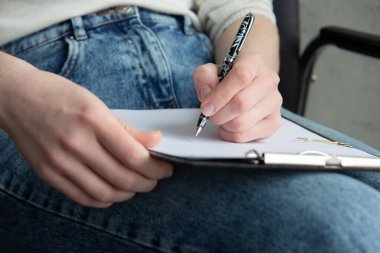 Woman's hand with a pen and a notebook. Filling out the diary