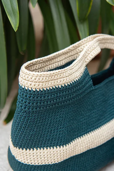 Blue knitted bag handmade outdoors. Sustainable shopping. Waste-free lifestyle. Do-it-yourself jute bag