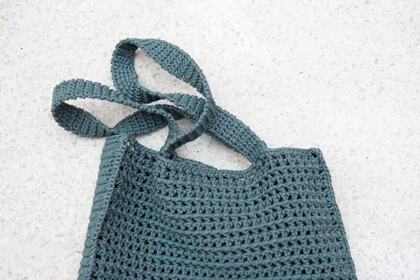Grey knitted bag handmade outdoors. Sustainable shopping. Waste-fr ee lifestyle. Do-it-yourself jute bag