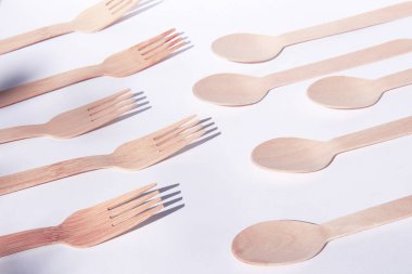 Tahta bambu çatal ve kaşıklar parlak beyaz arka planda.