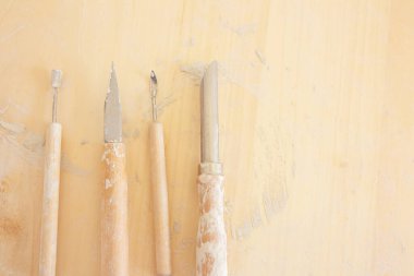 Seramik stüdyosunun arka planına yerleştirilmiş çömlek aletleri, zanaatkar sınıfları atölyesinde.