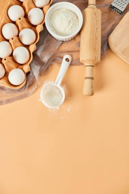 Pastane, mutfak iskeleti, malzemeler, pastel turuncu arka planda hamur işi için mutfak malzemeleri. Üst görünüm, alanı kopyala.