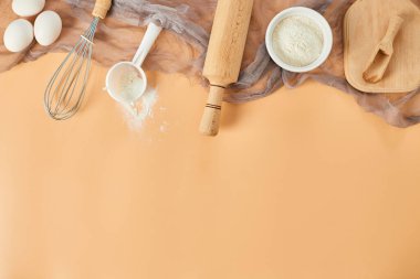 Pastane, mutfak iskeleti, malzemeler, pastel turuncu arka planda hamur işi için mutfak malzemeleri. Üst görünüm, alanı kopyala.