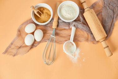 Pastane, mutfak iskeleti, malzemeler, pastel turuncu arka planda hamur işi için mutfak malzemeleri. Üst görünüm, alanı kopyala.