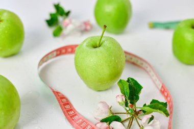 Ölçüm bandı olan yeşil elmalar, Sağlıklı Yaşam Tarzı Konsepti, Beyaz arka planda Diyet Sağlık Yemeği