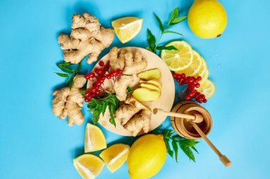 Bağışıklık güçlendirici ilacın düzlüğü, bağışıklık güçlendirici gıdalar zencefil, limon, bal, guelder gülü, mavi arka planda nane, Spac kopyala