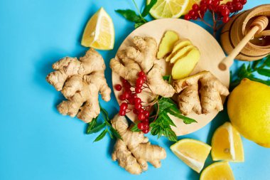 Bağışıklık güçlendirici ilacın düzlüğü, bağışıklık güçlendirici gıdalar zencefil, limon, bal, guelder gülü, mavi arka planda nane, Spac kopyala