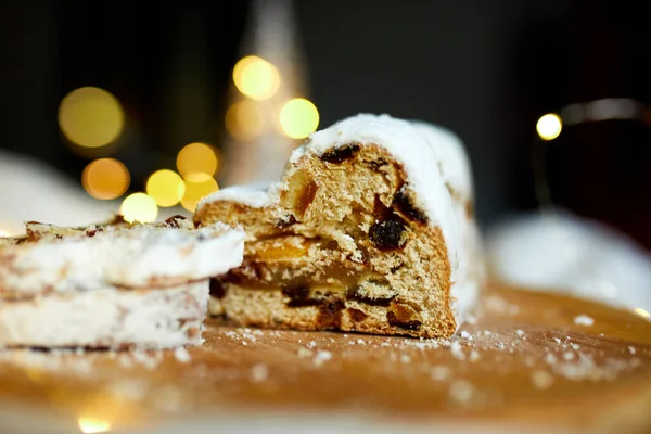 Homemade traditional marzipan Christmas Stollen on white background, with christmas lights and decorations