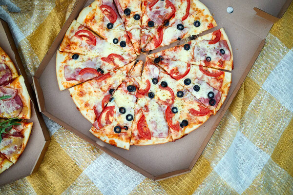 Two pizzas in the food carton on the grass, picnic concept, top view, copy space. Take away food, fastwood, italian pizza outdoor