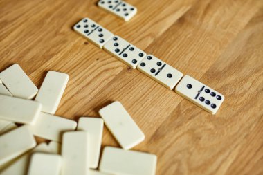 Tahta masa arkaplanındaki beyaz domino oyunlarının en üst görünümü kopya alanı, masa oyunu konsepti
