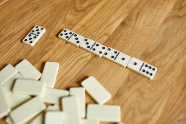 Tahta masa arkaplanındaki beyaz domino oyunlarının en üst görünümü kopya alanı, masa oyunu konsepti