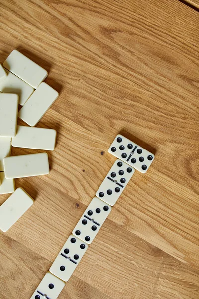 Top view of white domino games on wooden table background with copy space, board game concept