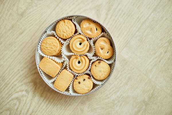 Top view tasty danish butter cookies in a tin box , set of crispy shortbread biscuits, baked pastry, sweet food, space for text.