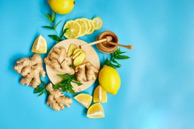  Immune boosting remedy, immunity boosting foods ginger, lemon,  honey,  mint on blue background, Flat lay Top view, copy spac