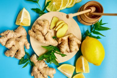  Immune boosting remedy, immunity boosting foods ginger, lemon,  honey,  mint on blue background, Flat lay Top view, copy spac