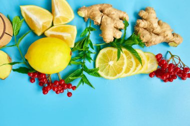 Bağışıklık güçlendirici ilacın düzlüğü, bağışıklık güçlendirici gıdalar zencefil, limon, bal, guelder gülü, mavi arka planda nane, Spac kopyala