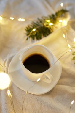 Yatakta bir fincan kahve, sargı bezleri, iğneler ve ışıklar, fotokopi alanı. Tebrik kartı, romantik kahvaltı, Noel konsepti.. 