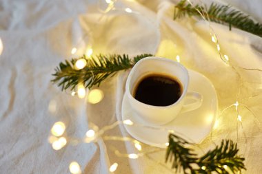 Yatakta bir fincan kahve, sargı bezleri, iğneler ve ışıklar, fotokopi alanı. Tebrik kartı, romantik kahvaltı, Noel konsepti.. 