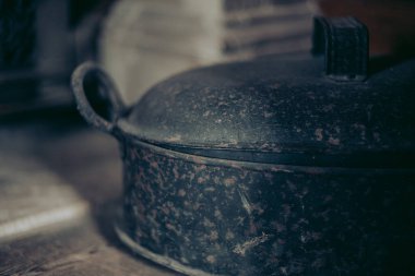 Selective focus on vintage metal pot in blurred background. Close up.