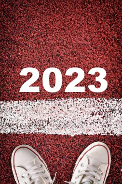 Yeni yıl 2023 ve kırmızı spor pistinde başlangıç çizgisi. Ticari başarı kavramı ve meydan okuma fikri