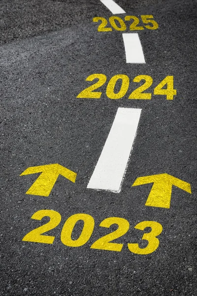 Road to year 2023, 2024, 2025 with yellow arrow marking on road. Making money retirement concept and motivation to business success idea